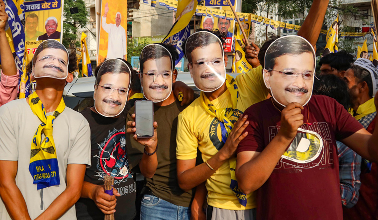 Supporters wear facemasks of Jailed Delhi Chief Minister Arvind Kejriwal during his wife Sunita Kejriwal's roadshow at Tilak Nagar in support of Aam Aadmi Party's  (AAP) candidate from West Delhi constituency Mahabal Mishra for the Lok Sabha polls, in New Delhi | PTI