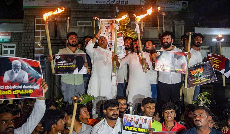 People take part in a torch light protest against Prajwal Revanna, in Bengaluru | PTI