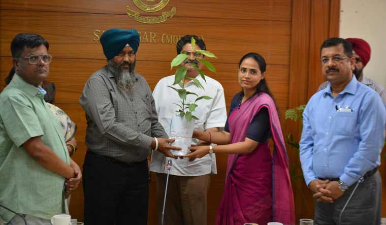 Dr Hira Lal, special observer for Anandpur Sahib constituency, handing over saplings to election officials at a meeting held to chalk out plans for general elections.