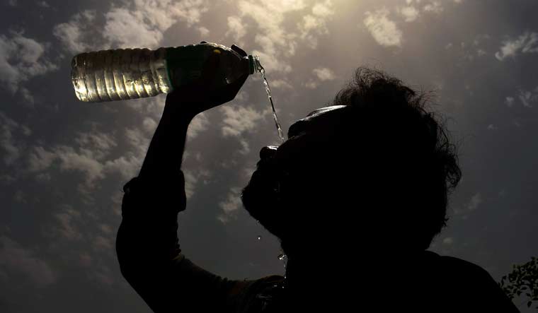 A man splashes water on his face on a hot summer day amid heatwave, in Gurugram | PTI