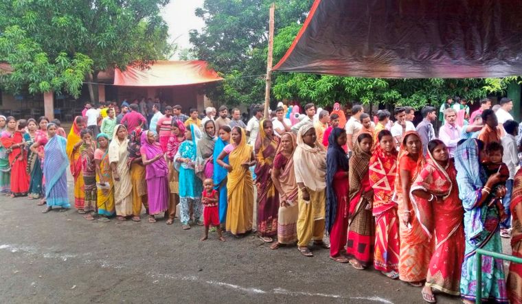 People wait a polling station to cast their votes in the seventh and last phase of Lok Sabha elections, in Jamtara district of Jharkhand | PTI