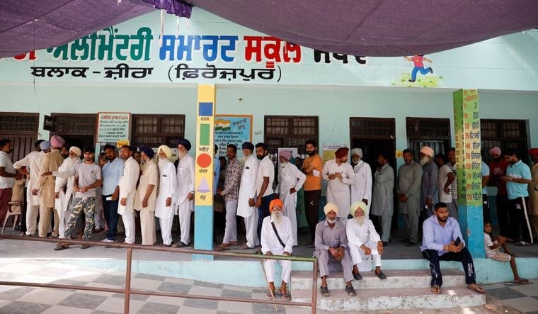 Voters stand in line to cast their votes at a polling station in Firozpur district, Punjab | Reuters