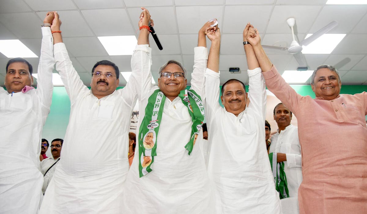 JD(U) Working President Sanjay Kumar Jha and state President Umesh Kushwaha join hands with senior IAS Manish Verma as he joins the party, in Patna | PTI