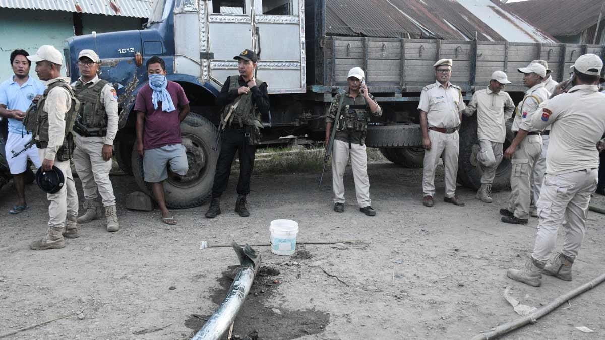 Police personnel and locals stand near the remains of a missile after it struck in Moirang, Manipur | Reuters