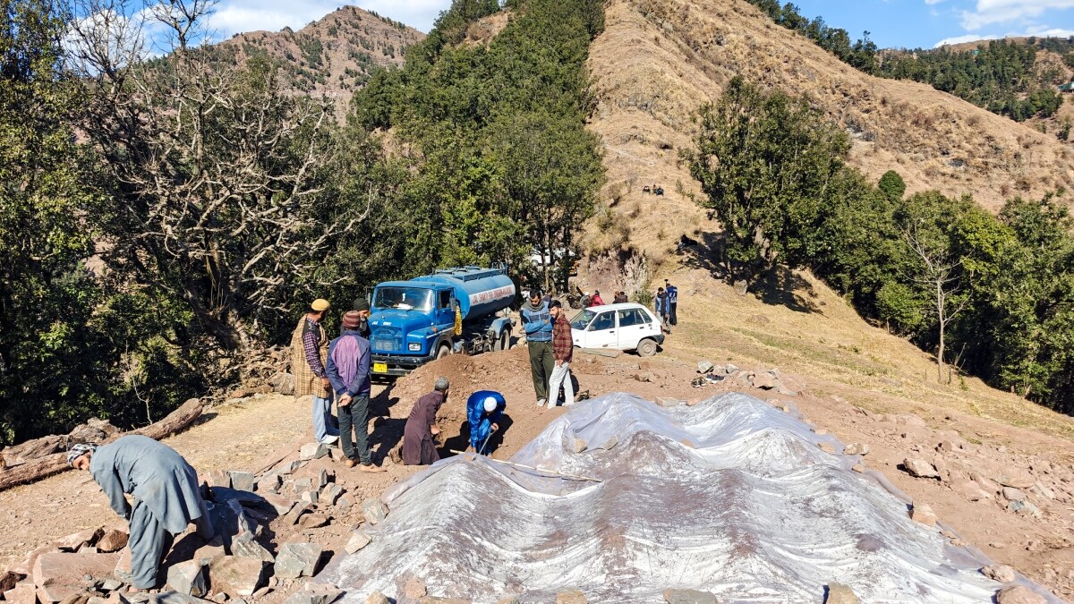 People dig a grave for the burial of Yasmeen Kouser, the 17th victim of the 'mysterious' illness, in Badhaal village of Rajouri district | PTI 