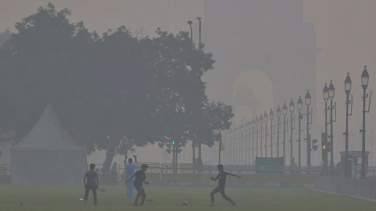 New Delhi: Children play football near India Gate as smog engulfs the area, with the Air Quality Index (AQI) remaining in the 'very poor' category, in New Delhi, Sunday, Nov. 2, 2025. (PTI Photo)(PTI11_02_2025_000042B)