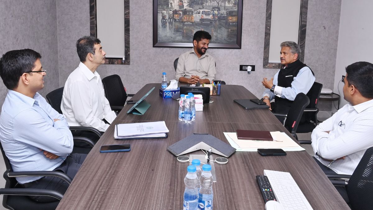 Telangana Chief Minister Revanth Reddy speaks to Mahindra Group chairman Anand Mahindra (2R)