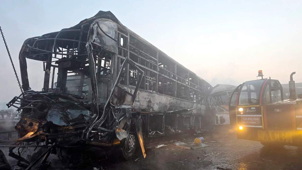 Cranes clear the charred remains of buses after a fog-hit pile-up involving several buses and cars triggered fires on the Yamuna Expressway, in Mathura | PTI