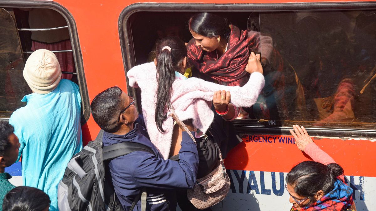 A man helps a girl to board an overcrowded train through an emergency window amid a huge rush owing to ongoing Prayagraj's Mahakumbh Mela, at the Patna Railway Station | PTI