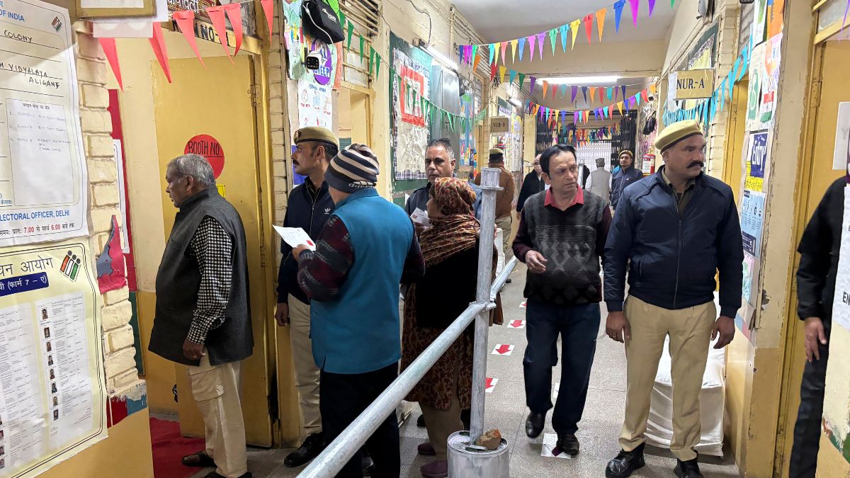 People stand in a queue to cast their votes for the capitals state legislature election at a polling booth in New Delhi | AP