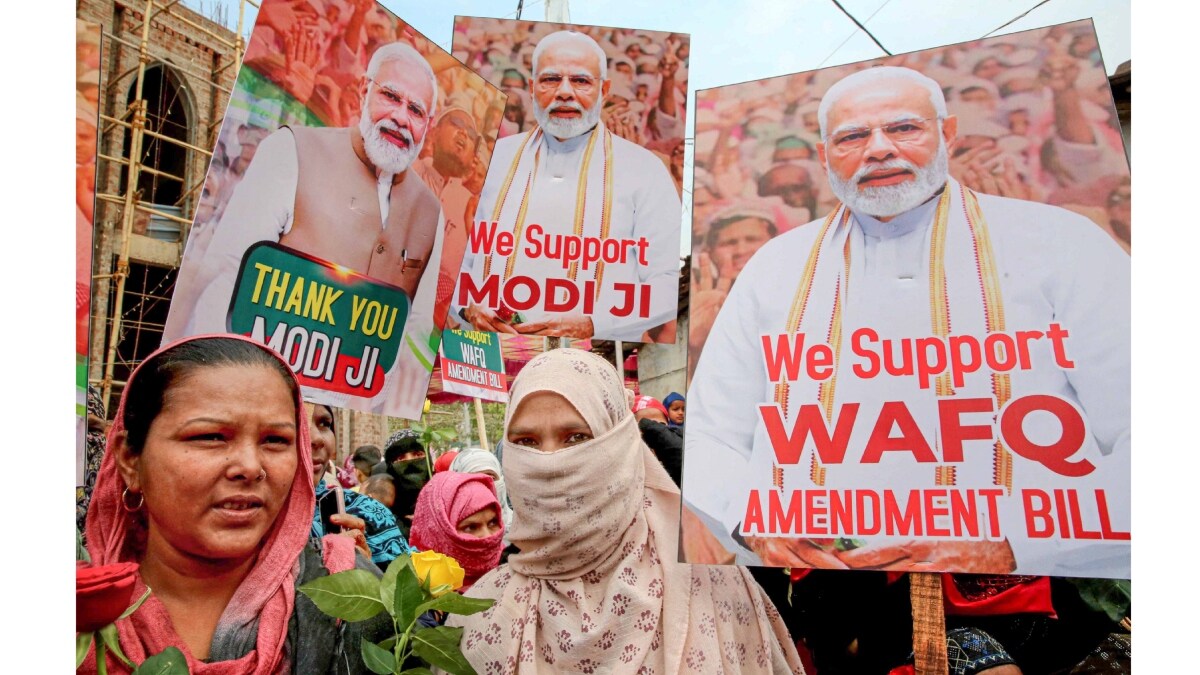 People hold placards in support of the Waqf Amendment Bill | PTI