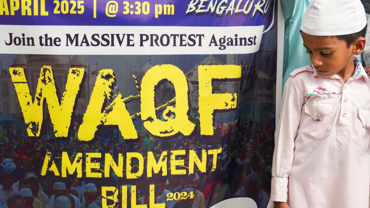 A boy stands near a poster during a protest against the passage of the Waqf (Amendmend) Bill in the Parliament, in Bengaluru | PTI