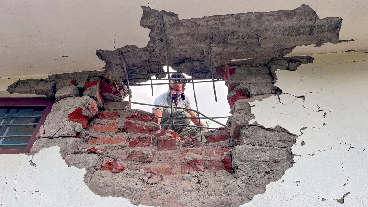 Poonch: A man looks through a damaged portion of a house after heavy firing and shelling by Pakistan military overnight across the Line of Control and International Border, at Mendhar area of Poonch district, Jammu and Kashmir, Wednesday, May 7, 2025. At least three civilians were killed and ten injured in the incident, according to officials.  (PTI Photo)(PTI05_07_2025_000181A)