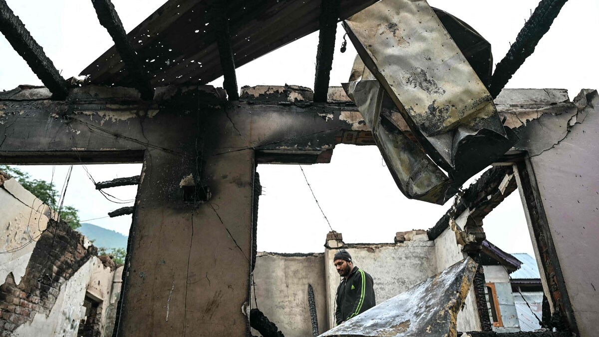 A man stands inside his house destroyed by Pakistani artillery shelling at the Salamabad village in Uri, about 110kms from Srinagar, on May 8, 2025. India's government said on May 8 that Pakistan launched an overnight air attack using "drones and missiles", before New Delhi retaliated to destroy an air defence system in Lahore. "Pakistan attempted to engage a number of military targets ... using drones and missiles," India's defence ministry said in a statement, adding that "these were neutralised" by air defence systems. (Photo by Sajjad HUSSAIN / AFP)