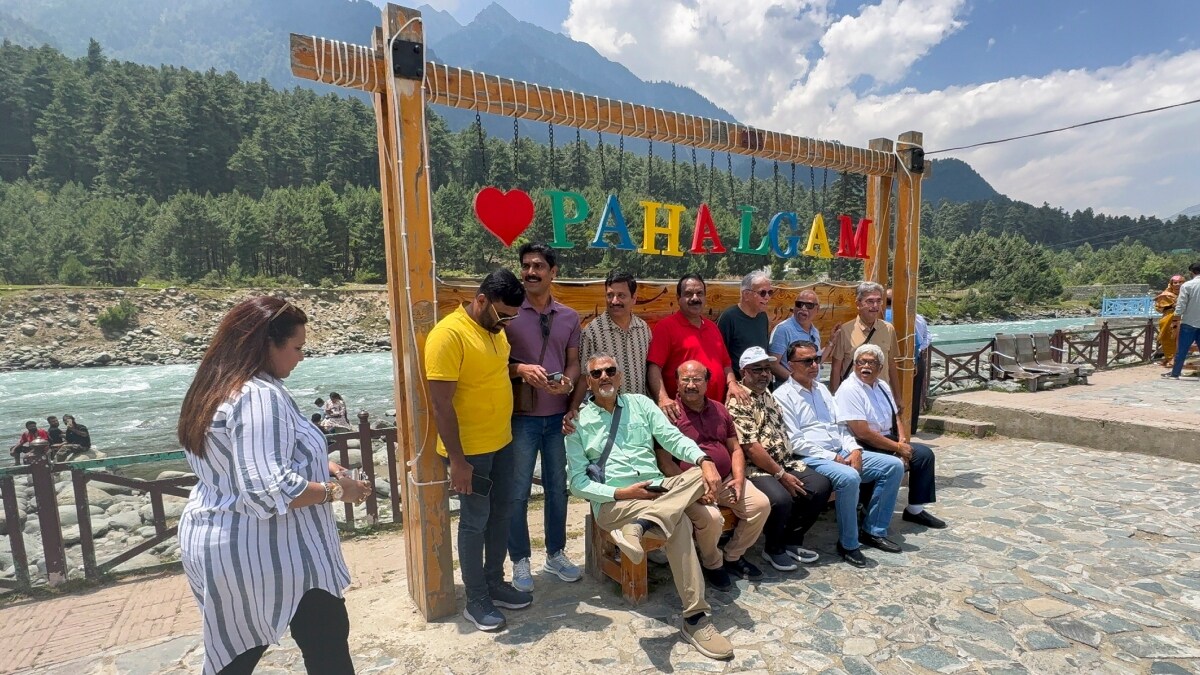 Tourists pose for a photograph as they visit Pahalgam in Jammu & Kashmir | PTI
