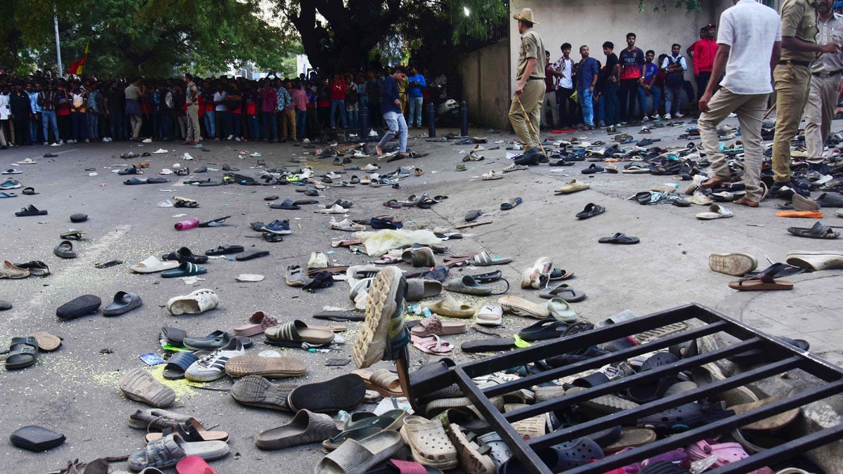 TOPSHOT - Fans stand next to abandonned shoes and a fallen barrier following a stampede during celebrations, a day after Royal Challengers Bengaluru's victory at the Indian Premier League (IPL) Twenty20 final cricket match, outside the M. Chinnaswamy Stadium in Bengaluru on June 4, 2025. At least 11 people were killed in a stampede on June 4, as a tightly packed crowd celebrated the victory of their home cricket team in the Indian city of Bengaluru, the state's chief minister said. (Photo by AFP)