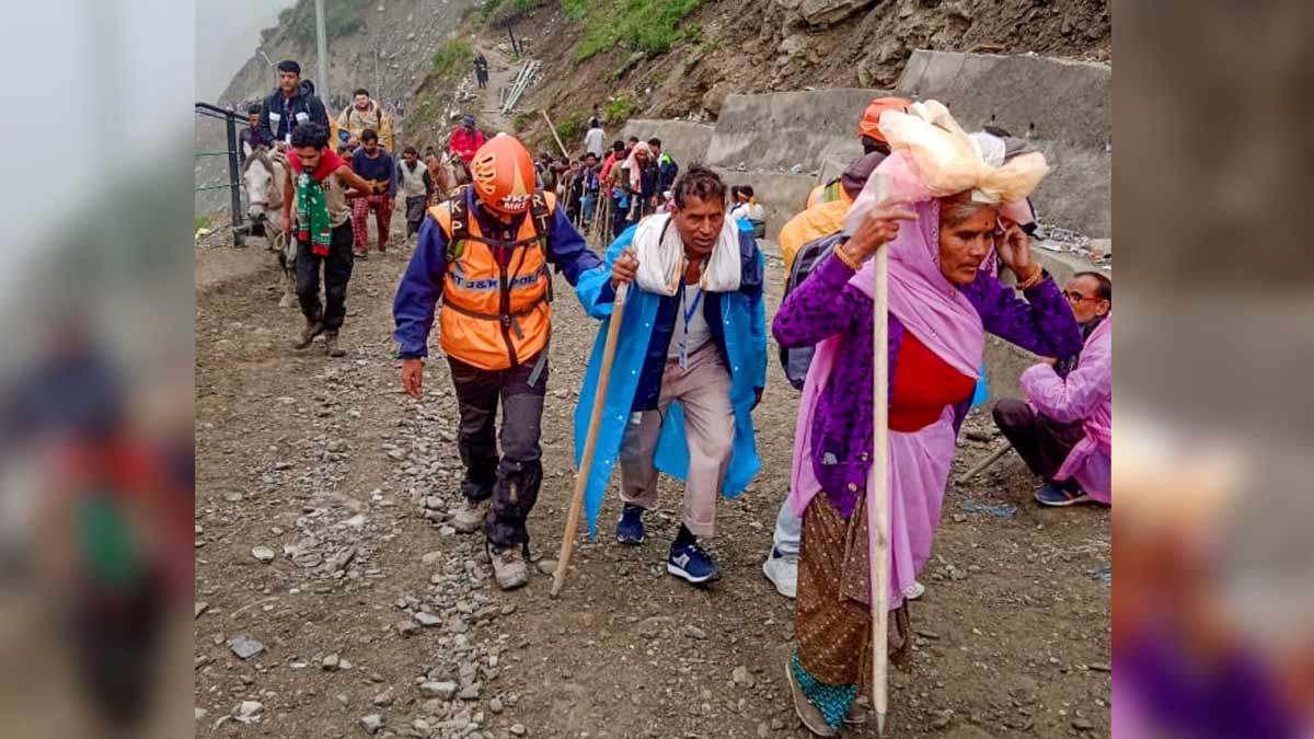 A member of Mountain Rescue Team (MRT) assists a pilgrim during the annual Amarnath Yatra, at Baltal area, in Ganderbal district | PTI