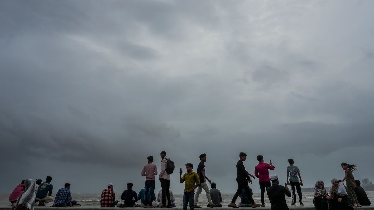 People at Marine Drive as dark clouds hover in the sky, in Mumbai | PTI 
