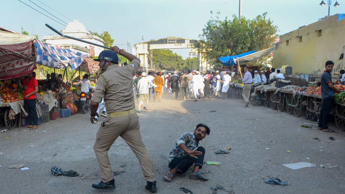 A security official lathi-charges a protester during a demonstration over the issue of 'I Love Mohammad' posters, in Bareilly | PTI