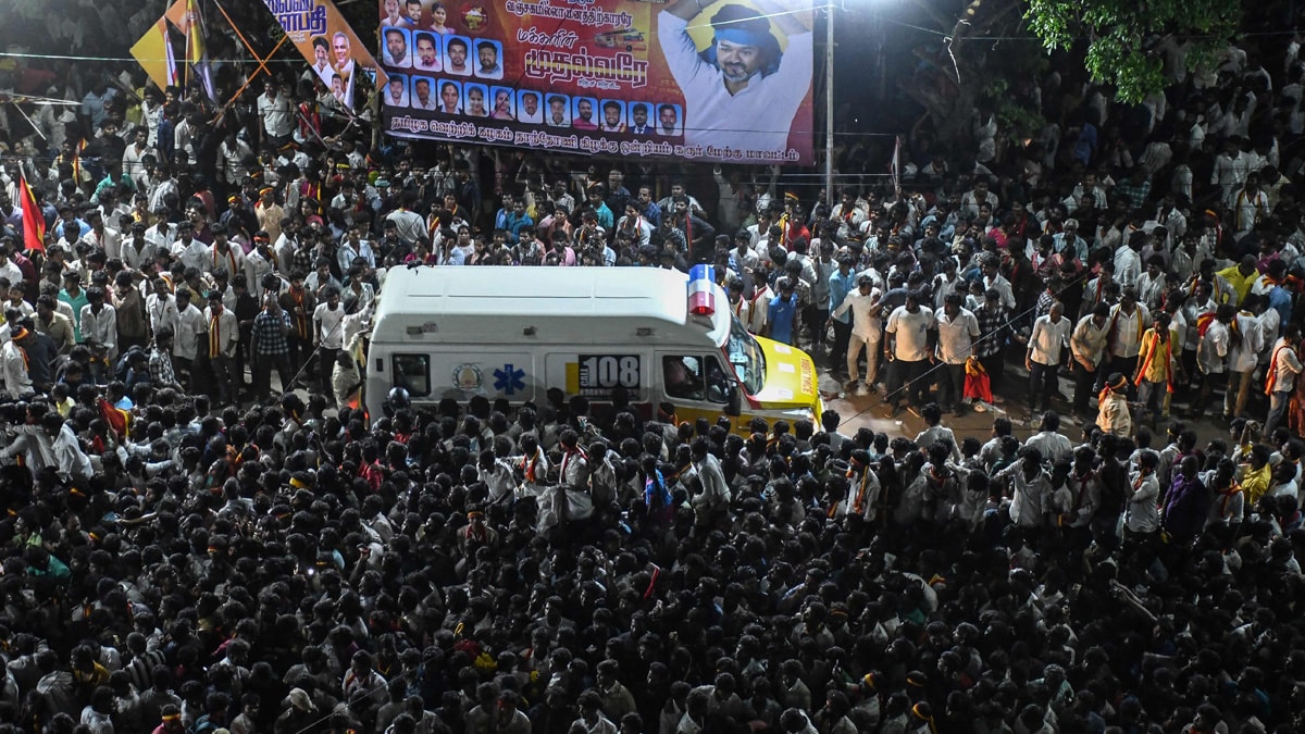 TOPSHOT - An ambulance carrying victims makes its way through the crowd following a stampede that broke out during a political rally in the Karur district, in the Indian state of Tamil Nadu, on September 27, 2025. A stampede that killed dozens at a south India political rally happened after a crowd of thousands waited hours in baking heat without sufficient safeguards, officials and witnesses said on September 28. Some 27,000 people thronged a public road in Tamil Nadu state in hopes of seeing popular actor-turned-politician Vijay on September 27, but panic broke out and 39 were killed, authorities said. (Photo by AFP)