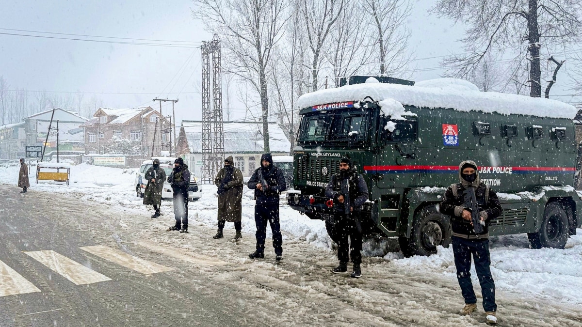 Jammu and Kashmir Police personnel keep vigil along the national highway amid snowfall | PTI