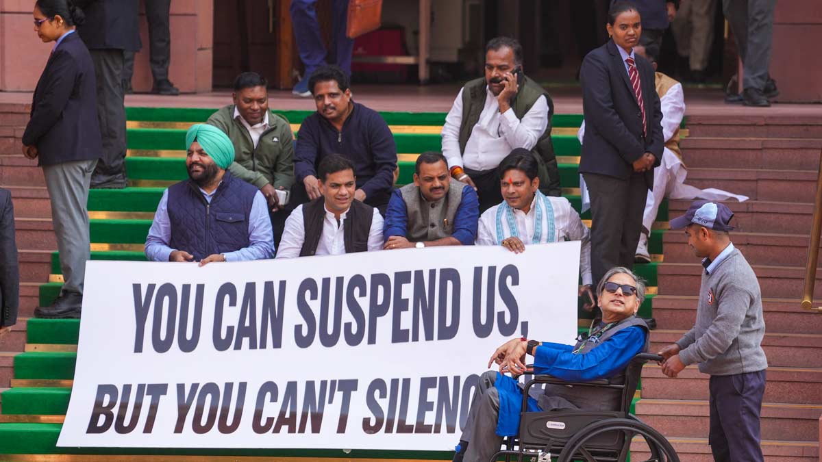 Congress MP Shashi Tharoor, seated in a wheelchair, arrives as suspended Lok Sabha MPs—who were barred from the remainder of the Budget session for "unruly behavior"—stage a protest on Parliament premises | PTI