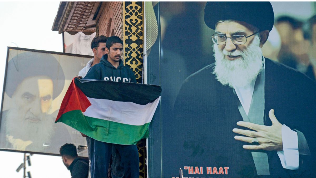 A protester holds a Palestinian flag beside a portrait of Iran's Supreme Leader Ali Khamenei during a protest against the alleged killing of Khamenei in US-Israel strikes, at Ghanta Ghar, in Srinagar | PTI