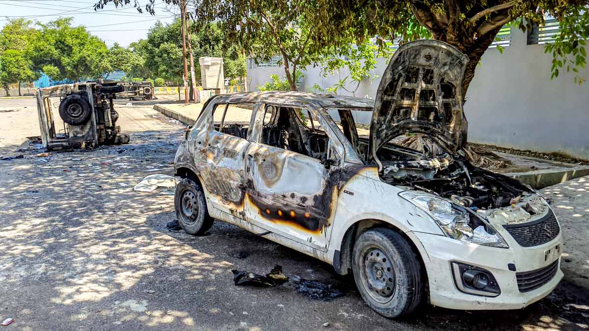 Wreckage of vehicles is seen after they were burnt during a protest by factory workers in Noida | PTI