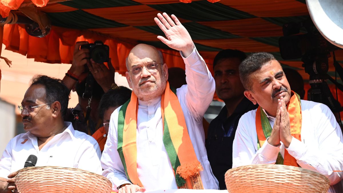 Union Home Minister Amit Shah (centre) waves to BJP supporters at a rally in Mamata Banerjee's bastion of Bhabanipur, joined by BJP leader Suvendu Adhikari (right) | Salil Bera