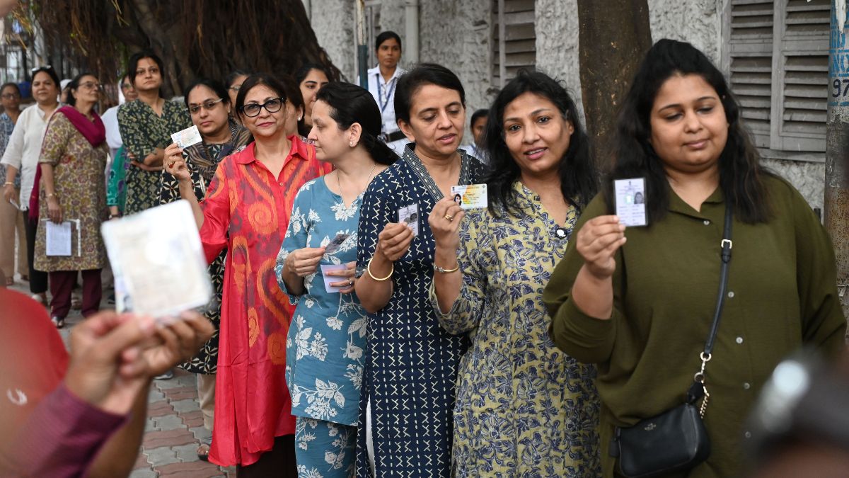 Women hold up their voter ID cards as they wait in line to cast their votes in the second and final phase of polling in West Bengal | Salil Bera