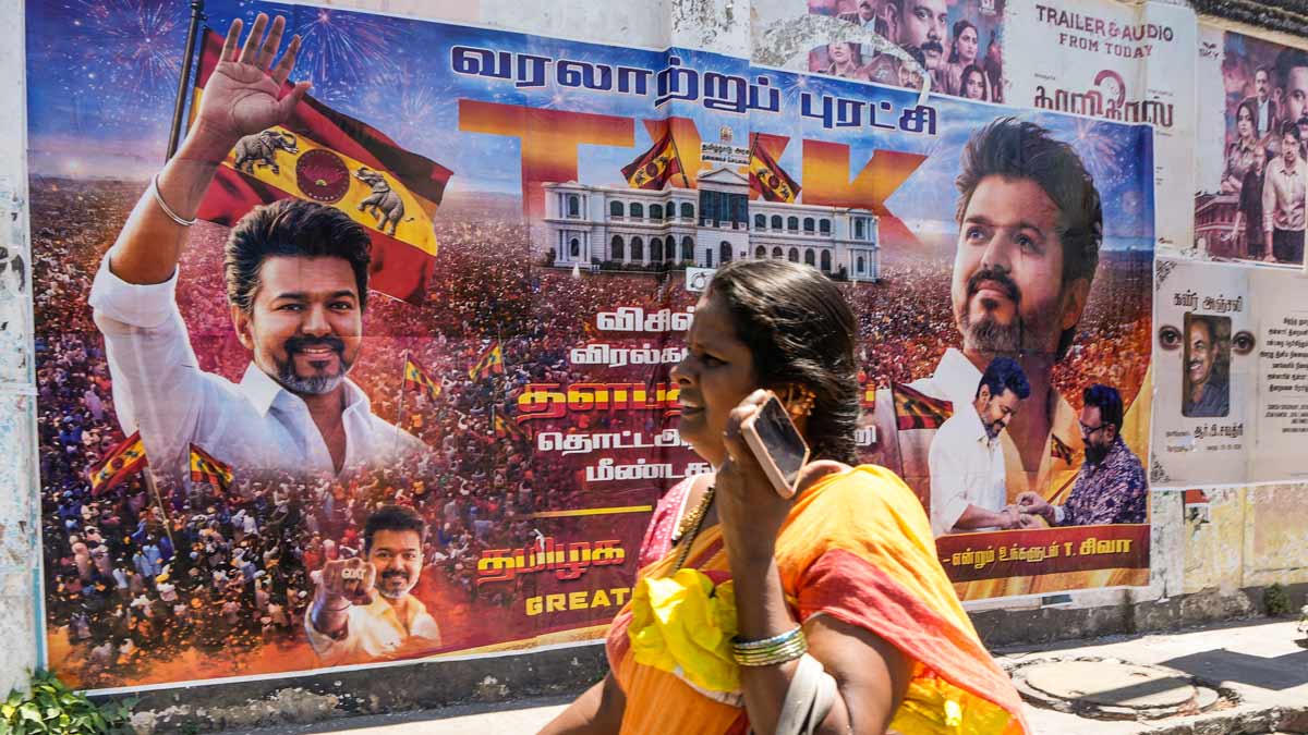 A woman walks past a banner of actor and TVK president Vijay in Chennai | PTI