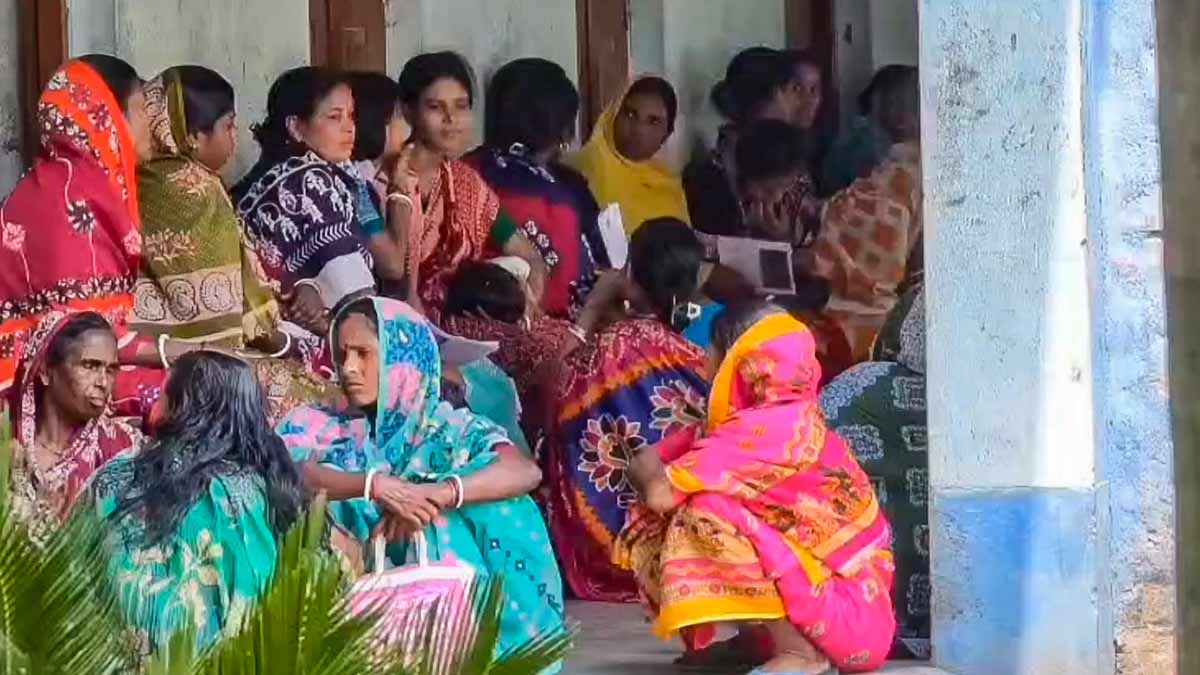 Voters wait outside a polling station after voting got halted due to alleged technical fault in EVM in South 24 Parganas district on Wednesday | PTI