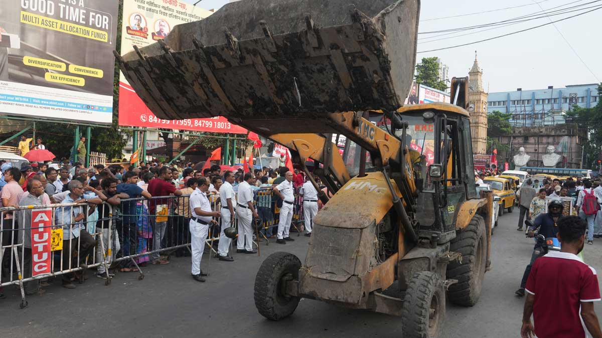 An earthmover passes by as members of the West Bengal Railway Hawkers Union (CITU) take part in a protest rally against the alleged forceful eviction of hawkers near Sealdah Railway Station, in Kolkata | PTI