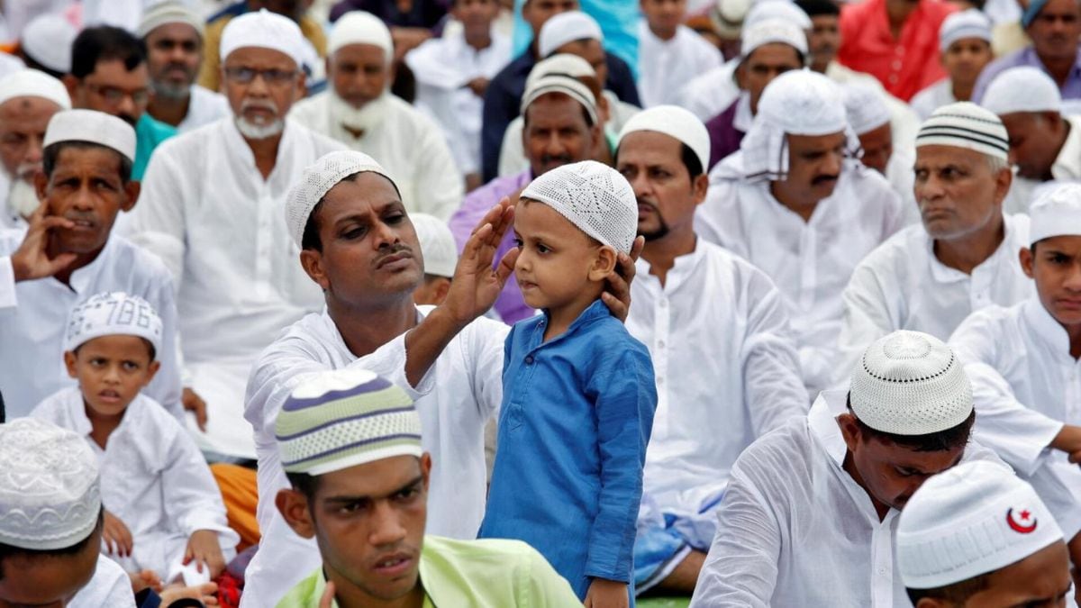 [File] A man adjusts his son's cap before Eid al-Fitr prayers | Reuters