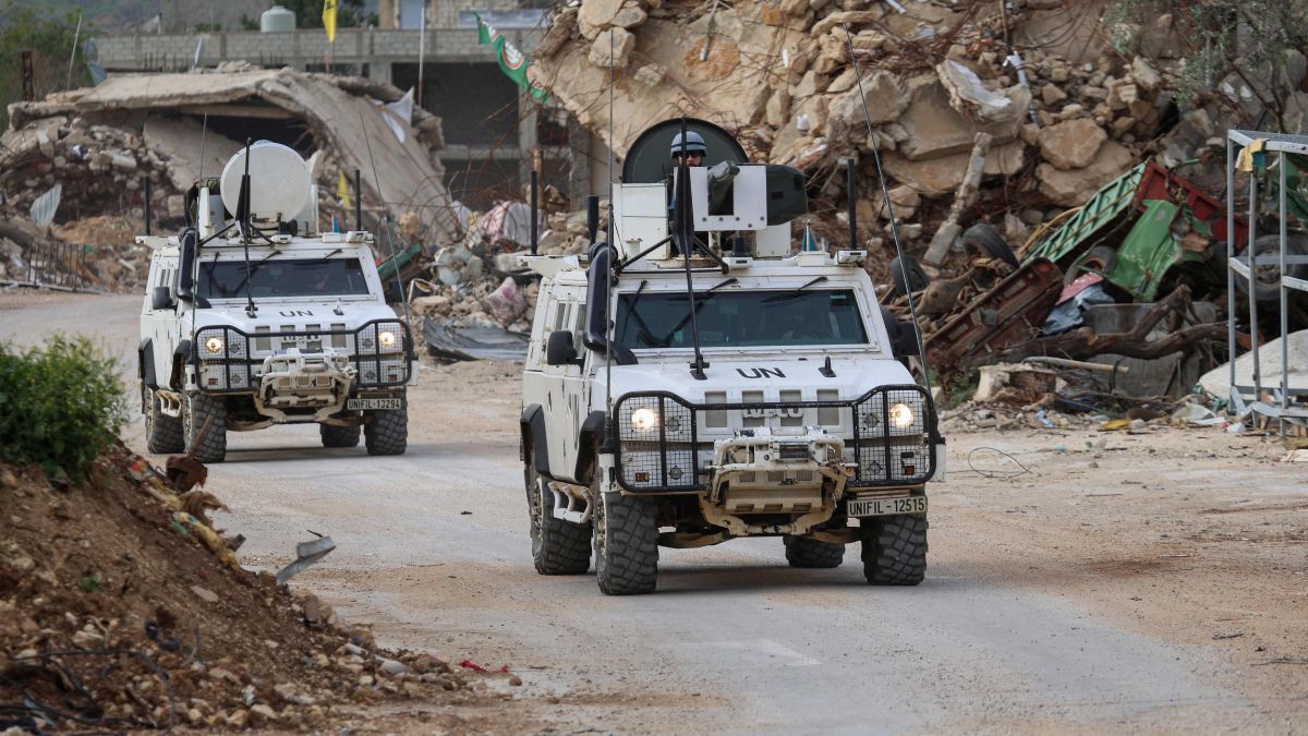United Nations peacekeepers drive in vehicles of the UN Interim Force in Lebanon (UNIFIL) past destroyed buildings while patroling in Lebanon's southern village of Kfar Kila close to the border with Israel | AFP 