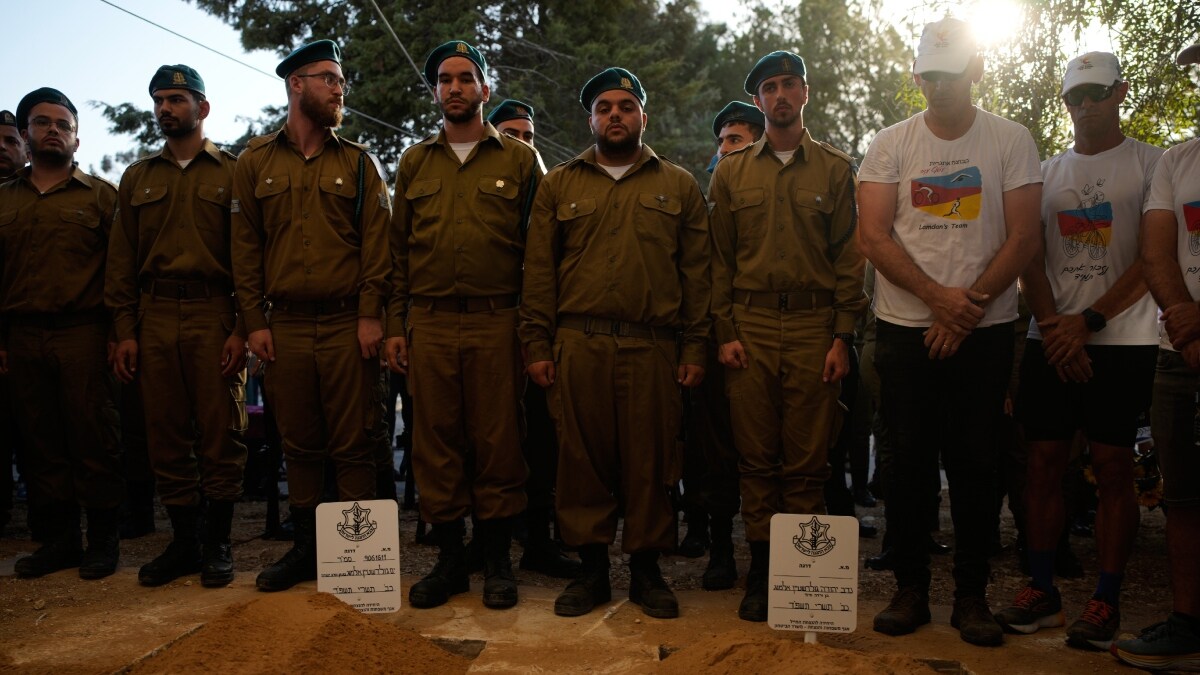 Mourners attend the reburial ceremony of a father and son who were killed by Hamas militants | Reuters
