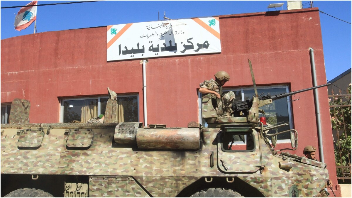 A Lebanese soldier sits on top of a military vehicle outside the municipality building of the southern Lebanese border village of Blida in the aftermath of an Israeli army raid | AFP