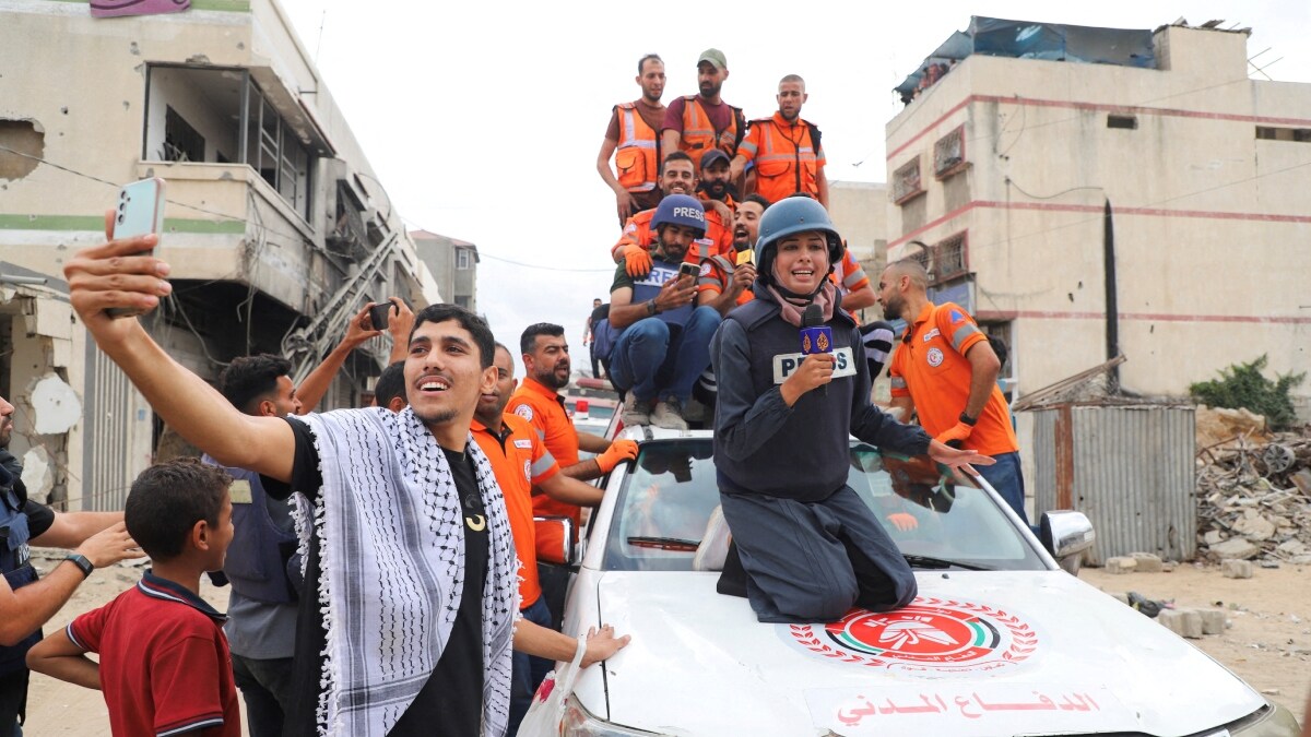 Journalists amidst celebrating Palestinian emergency personnel, after U.S. President Donald Trump announced that Israel and Hamas agreed on the first phase of a Gaza ceasefire | Reuters