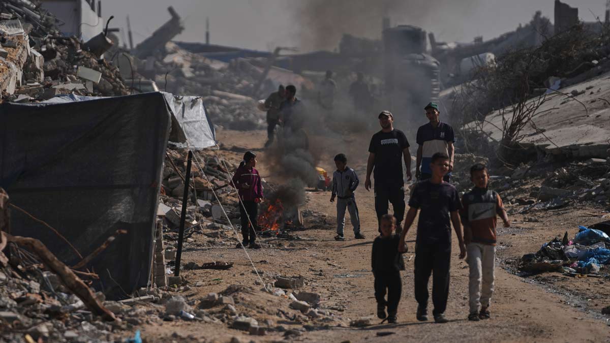 Displaced Palestinians light a fire to keep away mosquitoes amid the destruction left by Israeli air and ground offensive in Jabalia | AP