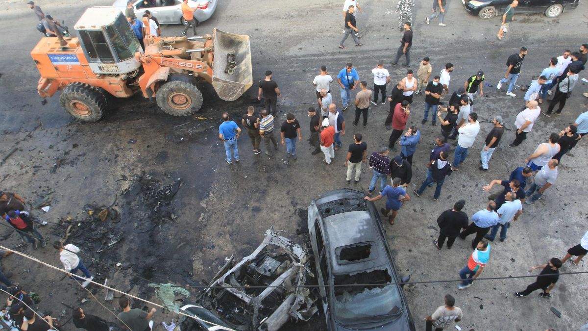 People gather at the site of an Israeli drone strike that targeted a vehicle in the southern Lebanese village of Ad Douwayr, near the city of Nabatieh | AFP