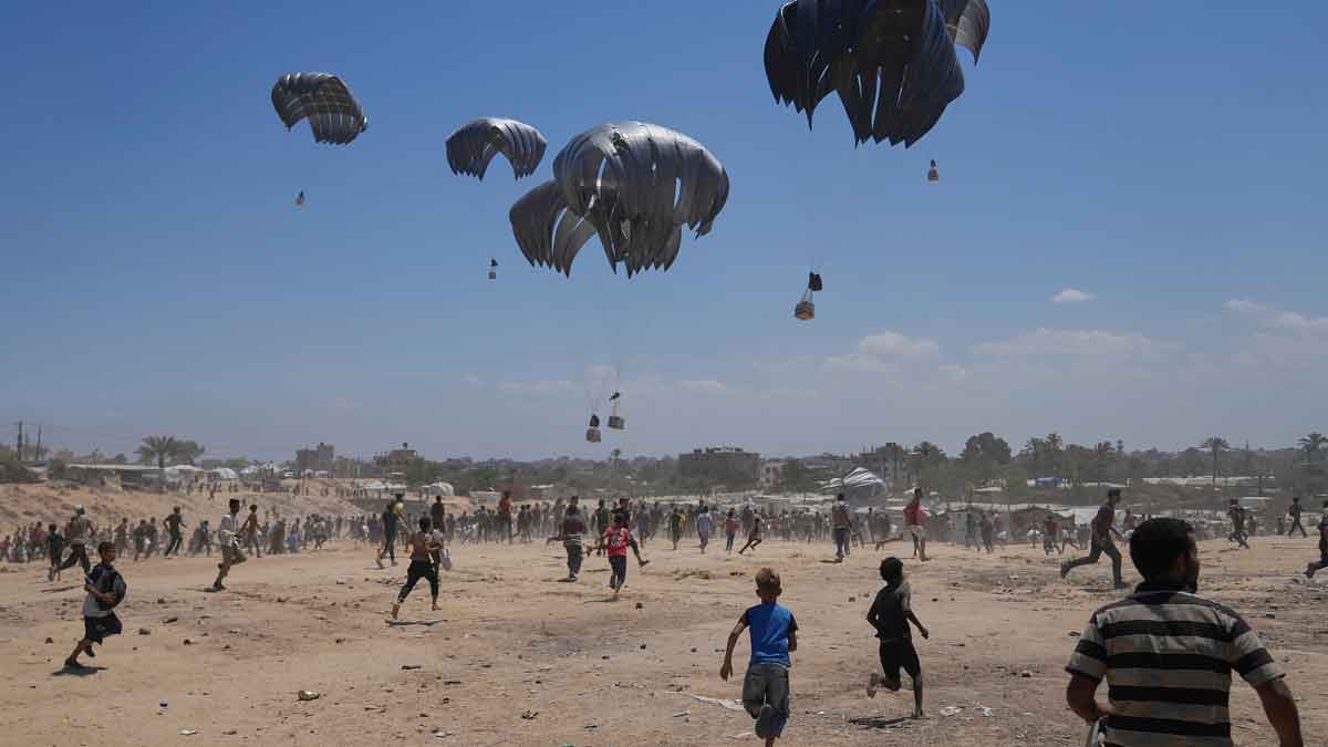 Palestinians rush to collect humanitarian aid airdropped by parachutes into Zawaida in the central Gaza Strip | AP