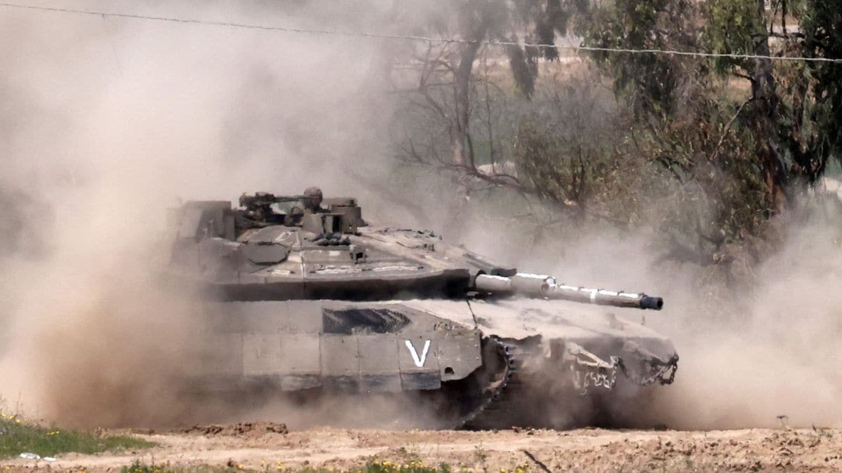 An Israeli army Merkava main battle tank moves at a position in southern Israel along the border fence with the northern Gaza Strip on March 18, 2025 | AFP
