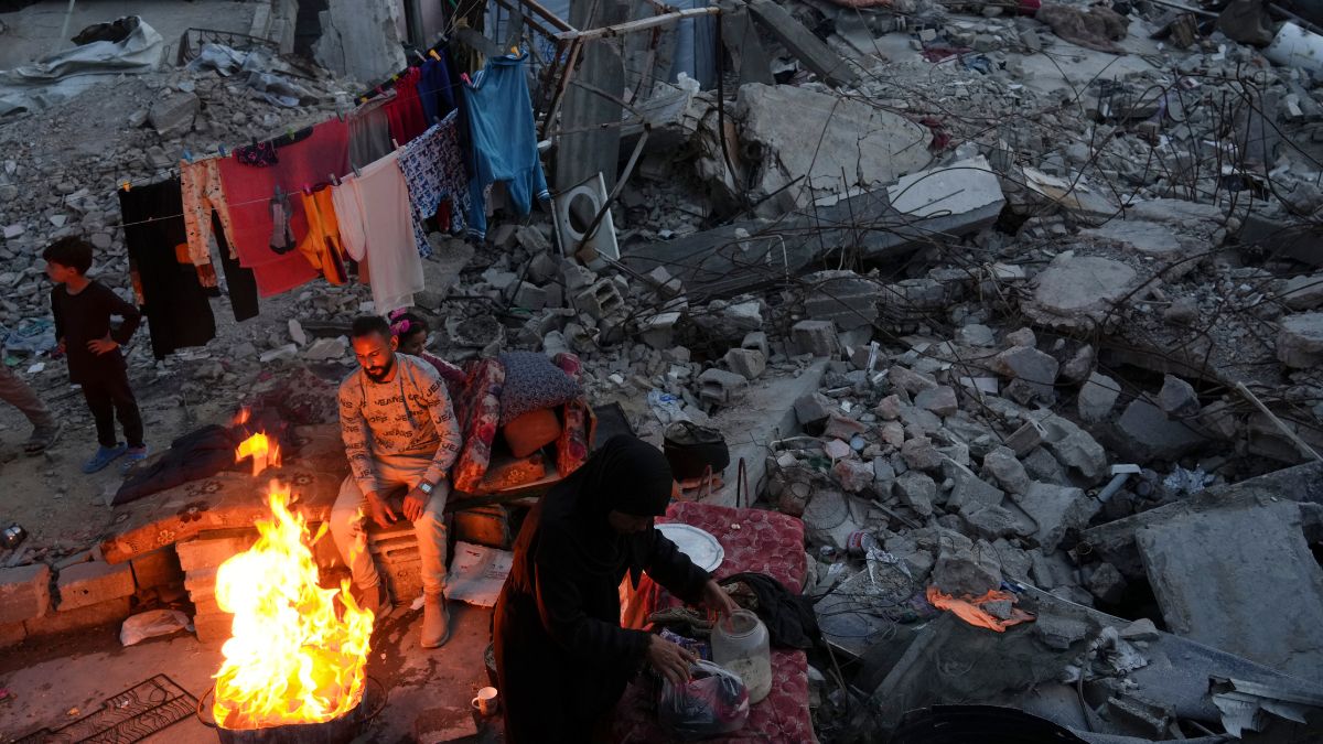 Members of Palestinian Marouf family cook outside their destroyed house by the Israeli army's air and ground offensive in Jabaliya, Gaza Strip | AP 