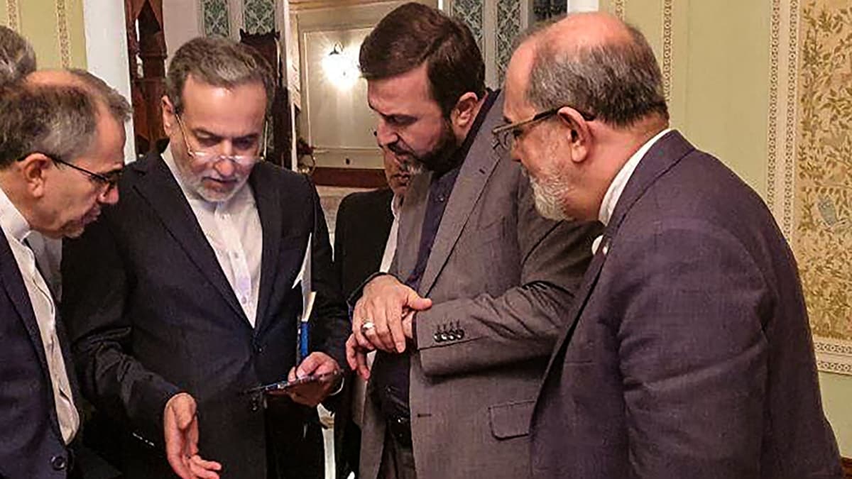 This handout picture provided by Khabar Online on April 12, 2025, shows Iran's Foreign Minister Abbas Araghchi (2nd-L) speaking with members of the Iranian delegation after a meeting in Muscat. | AFP