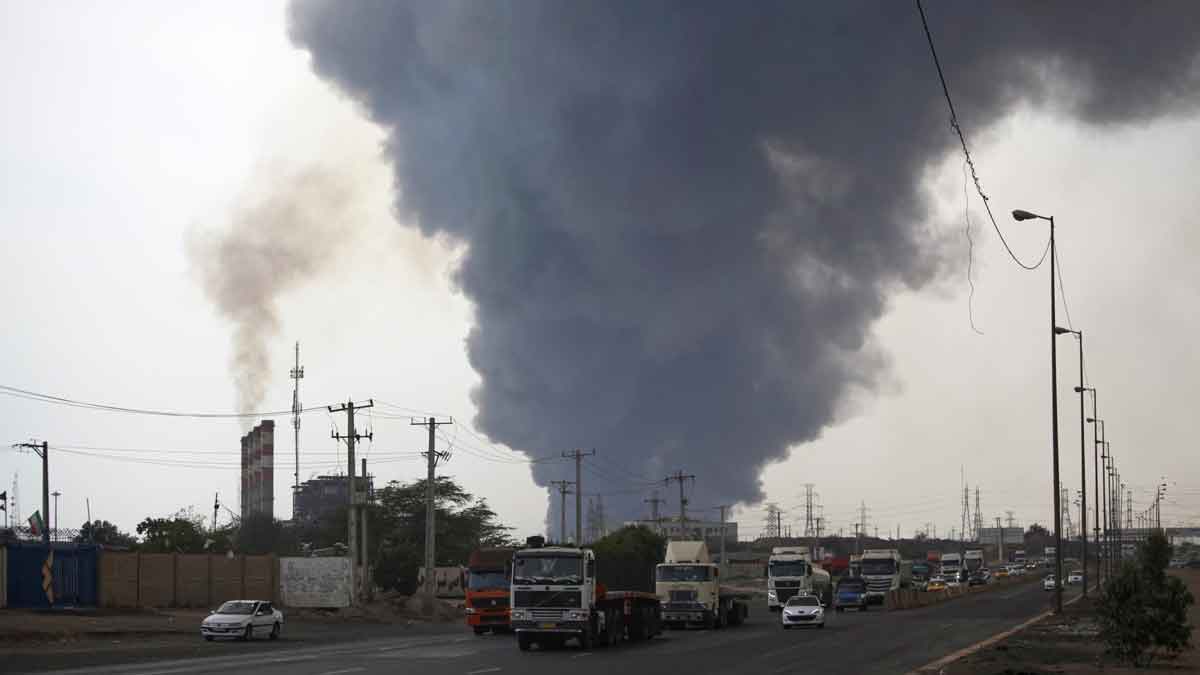A black smoke rises in the sky as vehicles drive on the road after a massive explosion rocked a port near the southern port city of Bandar Abbas, Iran | AP
