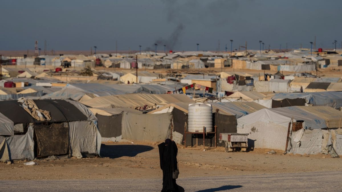 A woman walks in the al-Hol camp in northeastern Syria's Hasakeh province, where tens of thousands of mostly women and children linked to the Islamic State group have been living for years | AFP