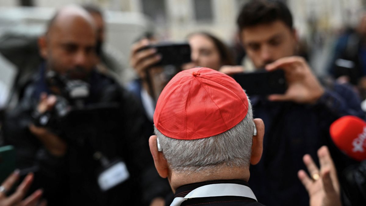 A cardinal speaks to the media as he arrives for a general congregation meeting ahead of the conclave to elect the next pope, as seen from Rome | Reuters