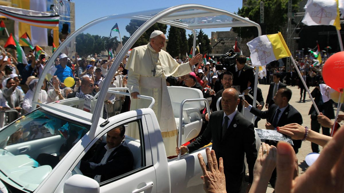 Pope Francis waves to the crowd, from his popemobile, as he arrives at the Manger Square before presiding over an open-air mass on May 25, 2014 outside the Church of the Nativity in the West Bank Biblical town of Bethlehem | AFP 