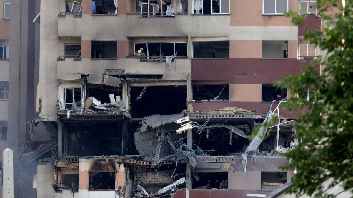 Rescue teams work in a building targeted by an Israeli strike in the Iranian capital Tehran | AFP
