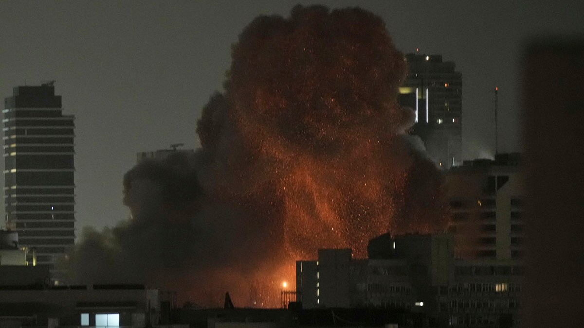 An explosion is seen during a missile attack in Tel Aviv, Israel, Sunday, June 15, 2025. (AP Photo/Leo Correa)